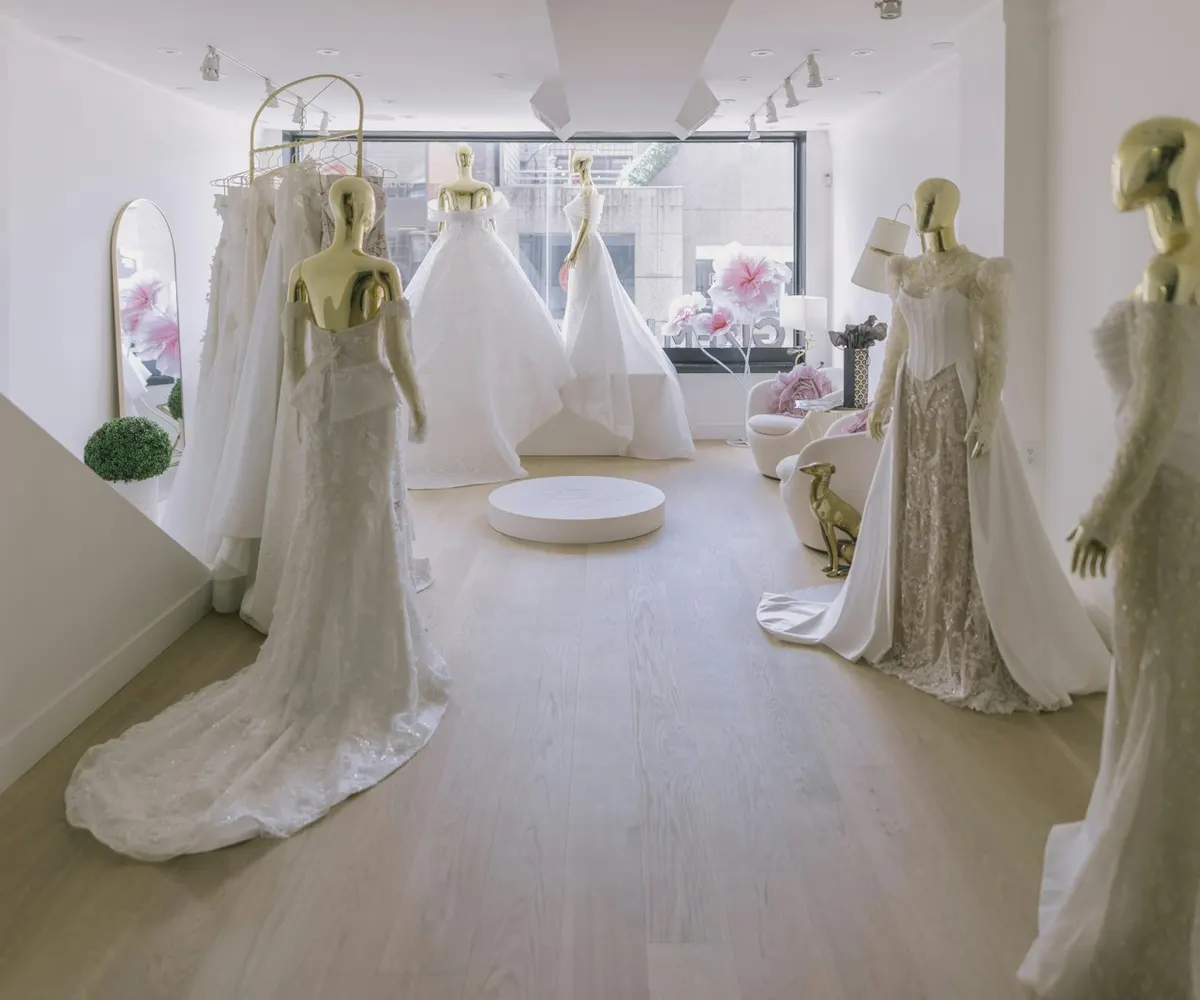 Wedding gowns on display in a sunlit bridal boutique.