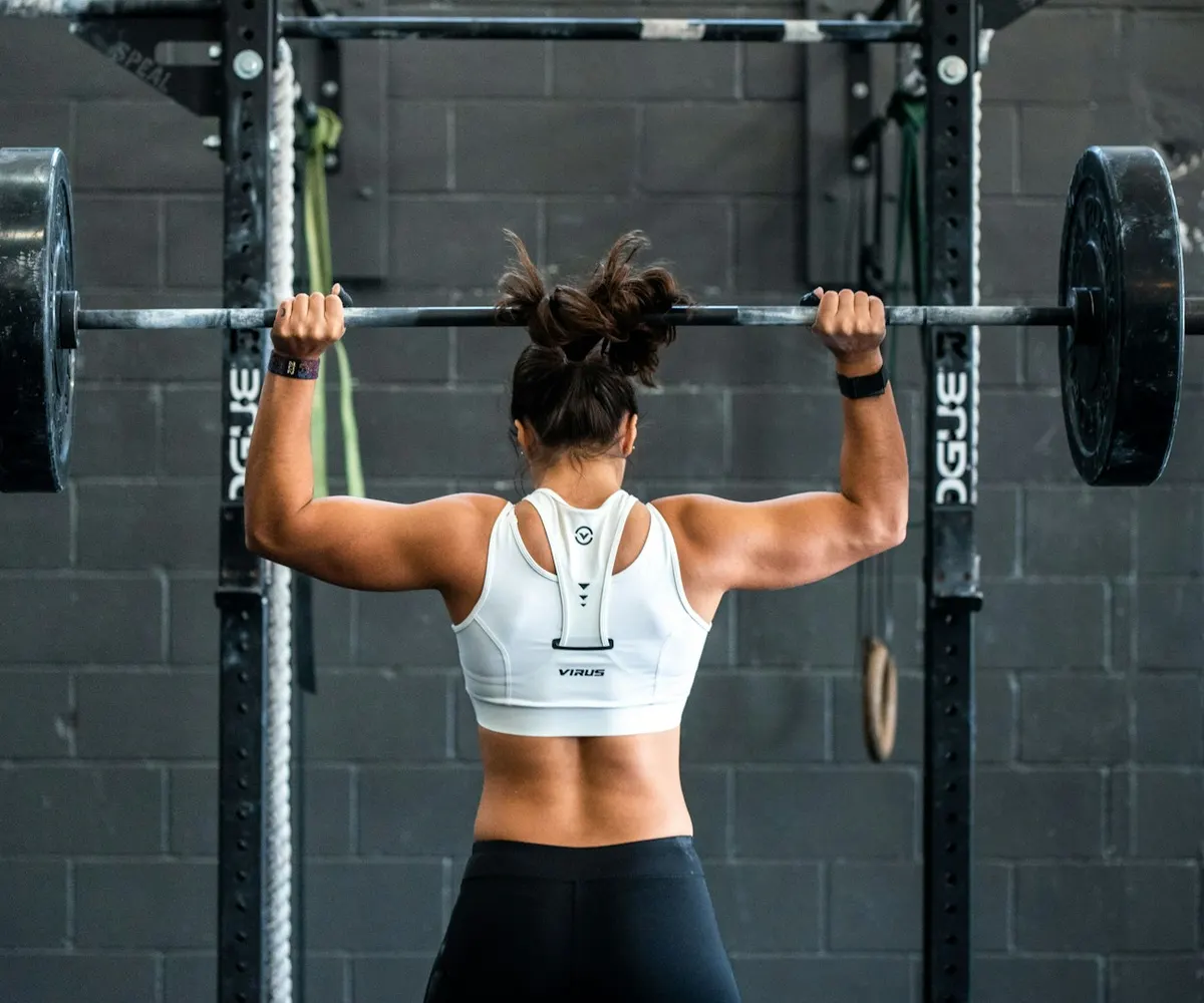 A person training with free weights in a gym.
