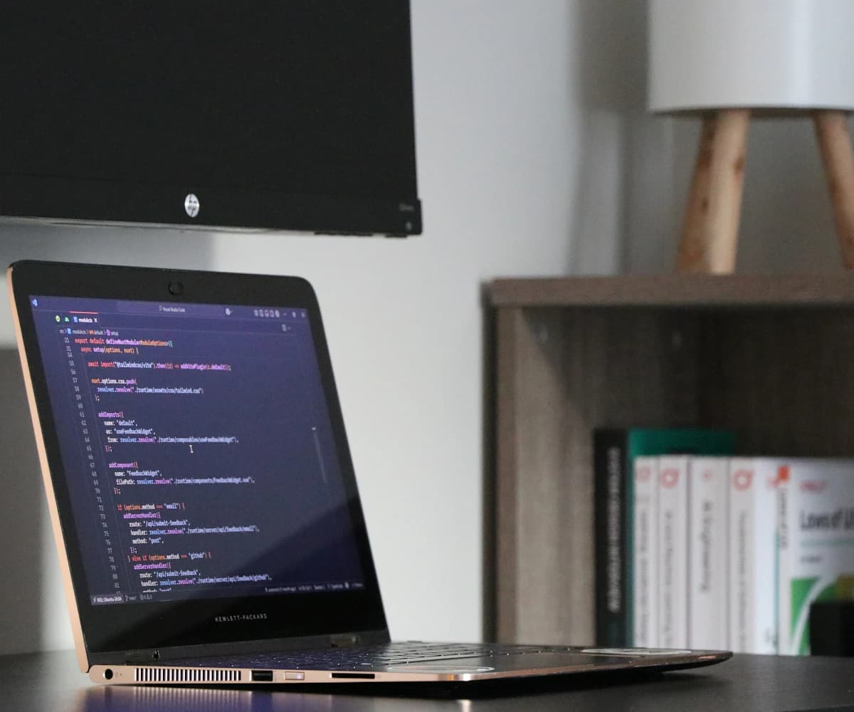 A laptop showing software code in a working space.
